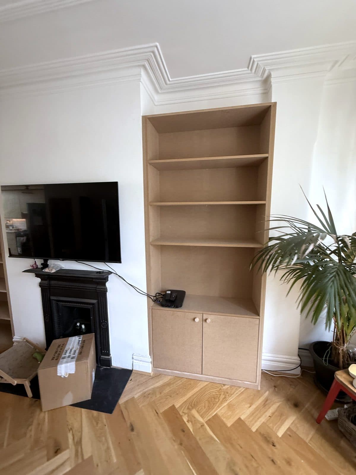 Alcove unit with a cupboard, beside the TV and fireplace