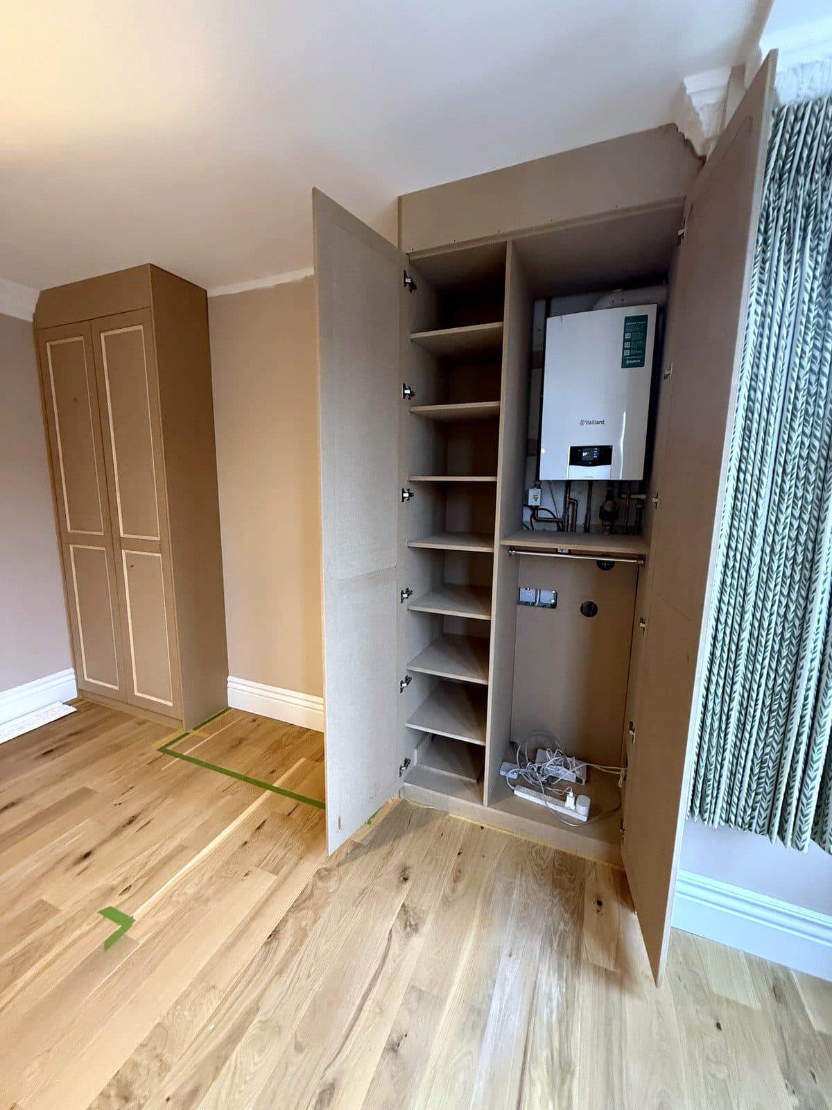 Right wardrobe open, with shelves on one side and the boiler on the other