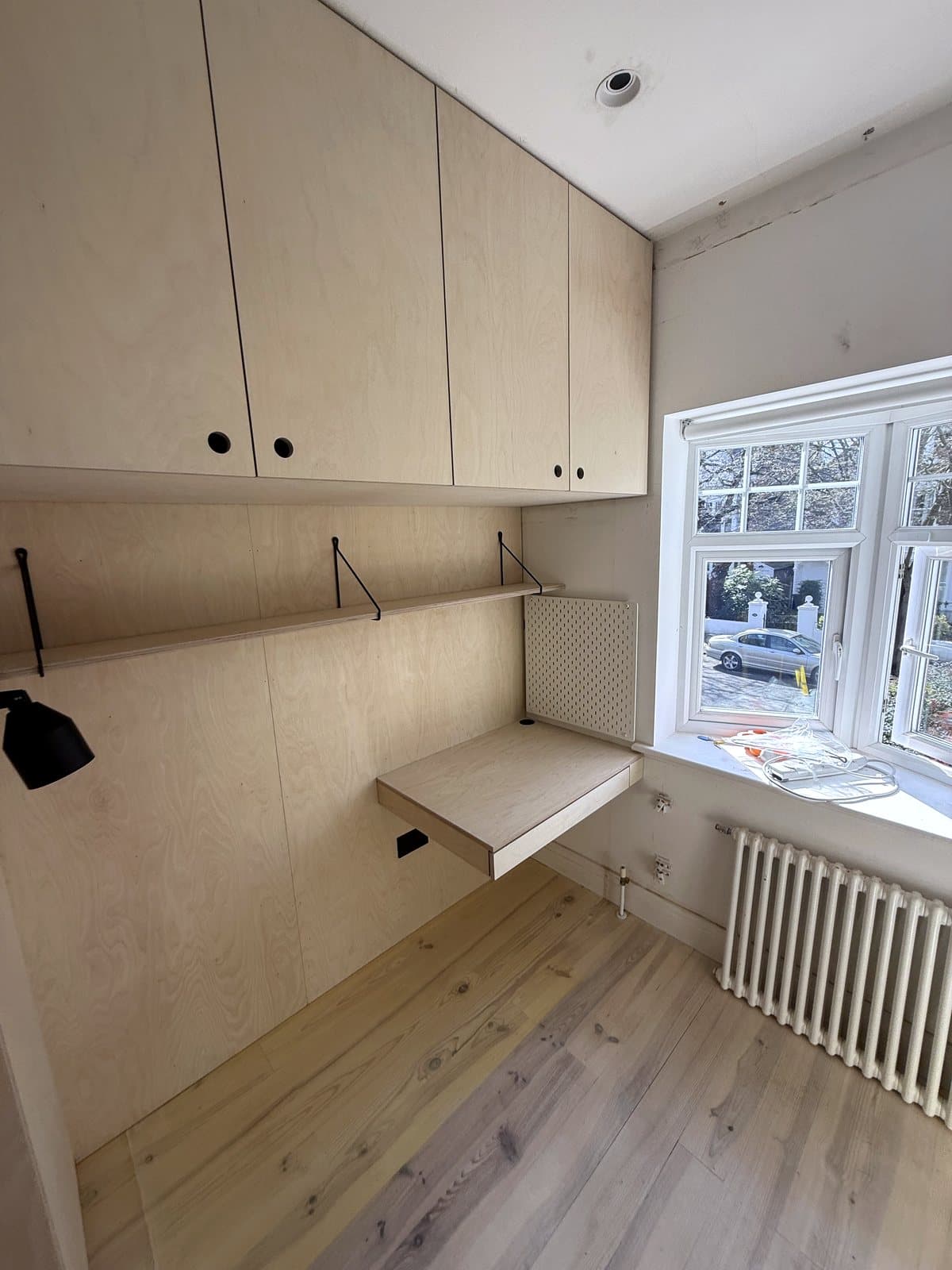 Desk under the window with the shelf above