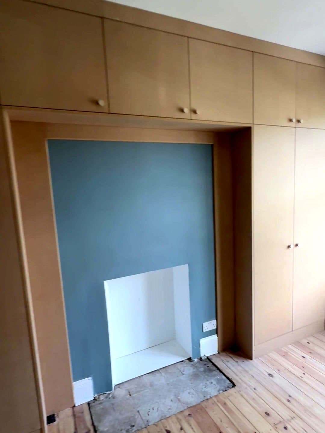 The whole wall of wardrobes with the fireplace in the middle