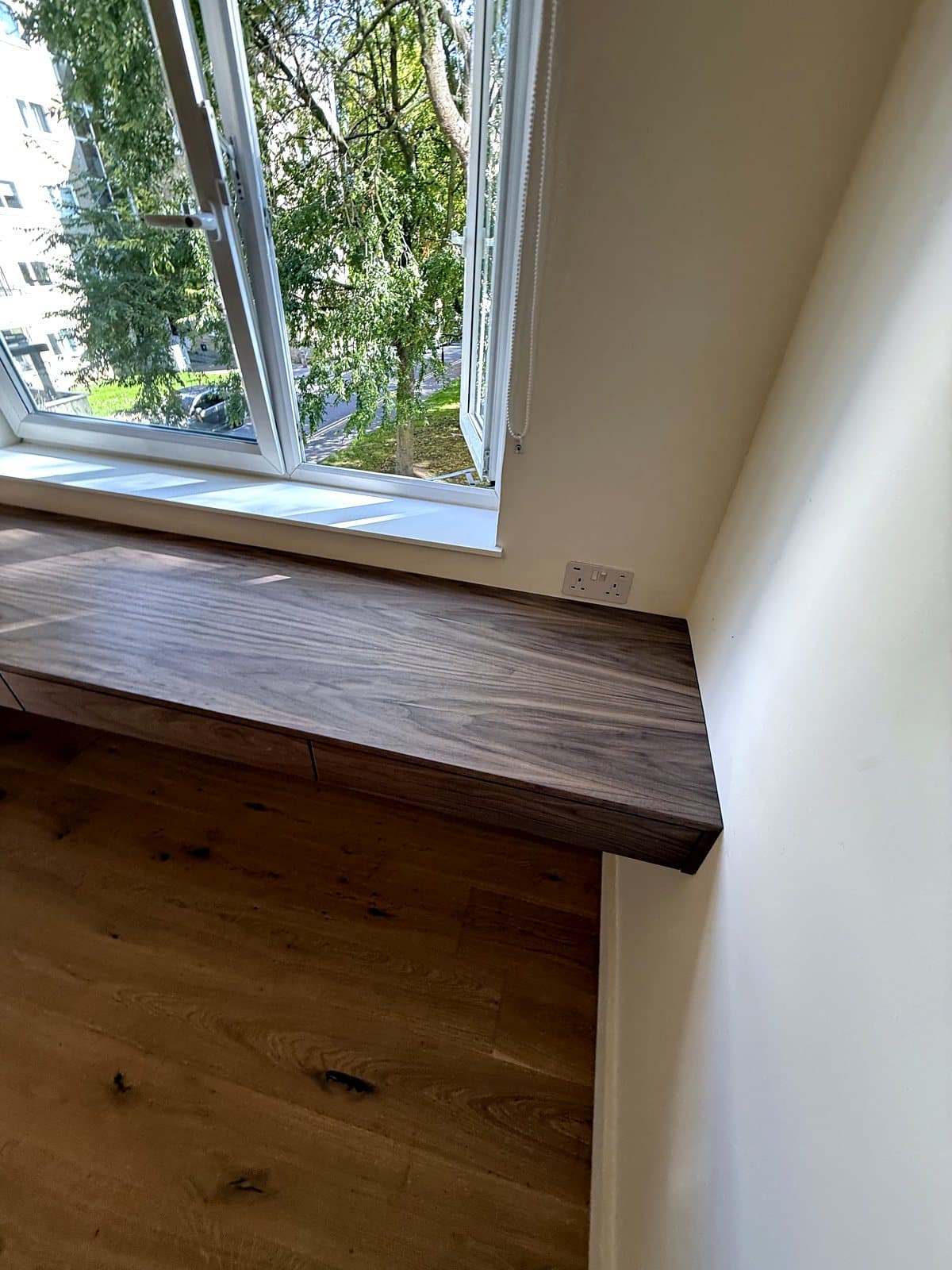 The front edge of the desk by the window