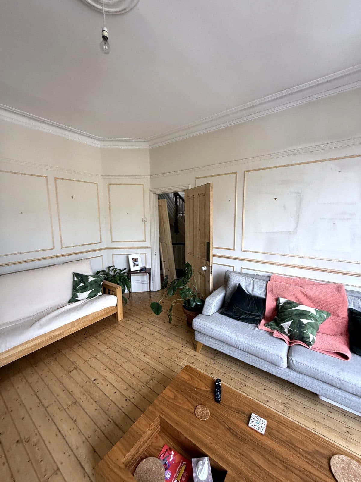 Panelling behind the sofa, next to the door