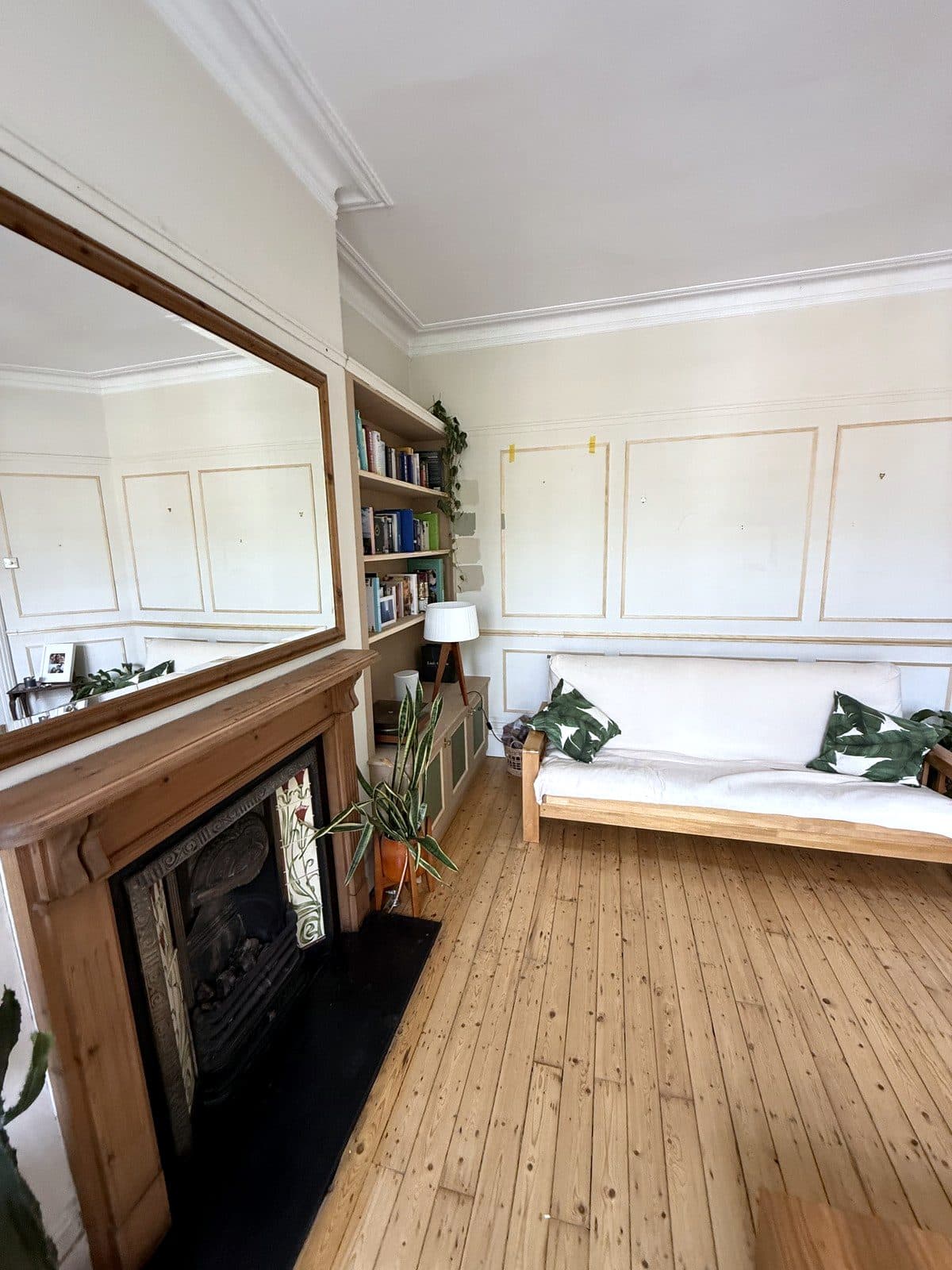Panelling continuing past the bookcase and the fireplace