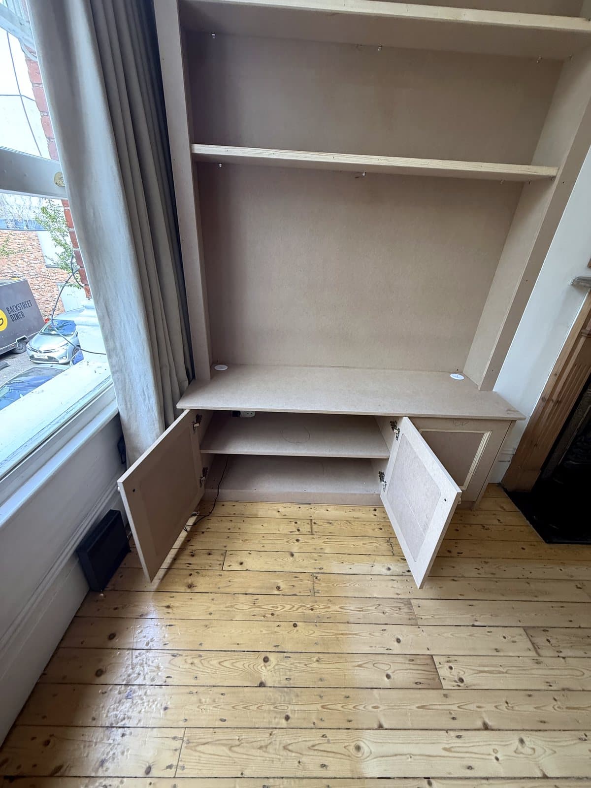 Cupboard doors open on the TV side