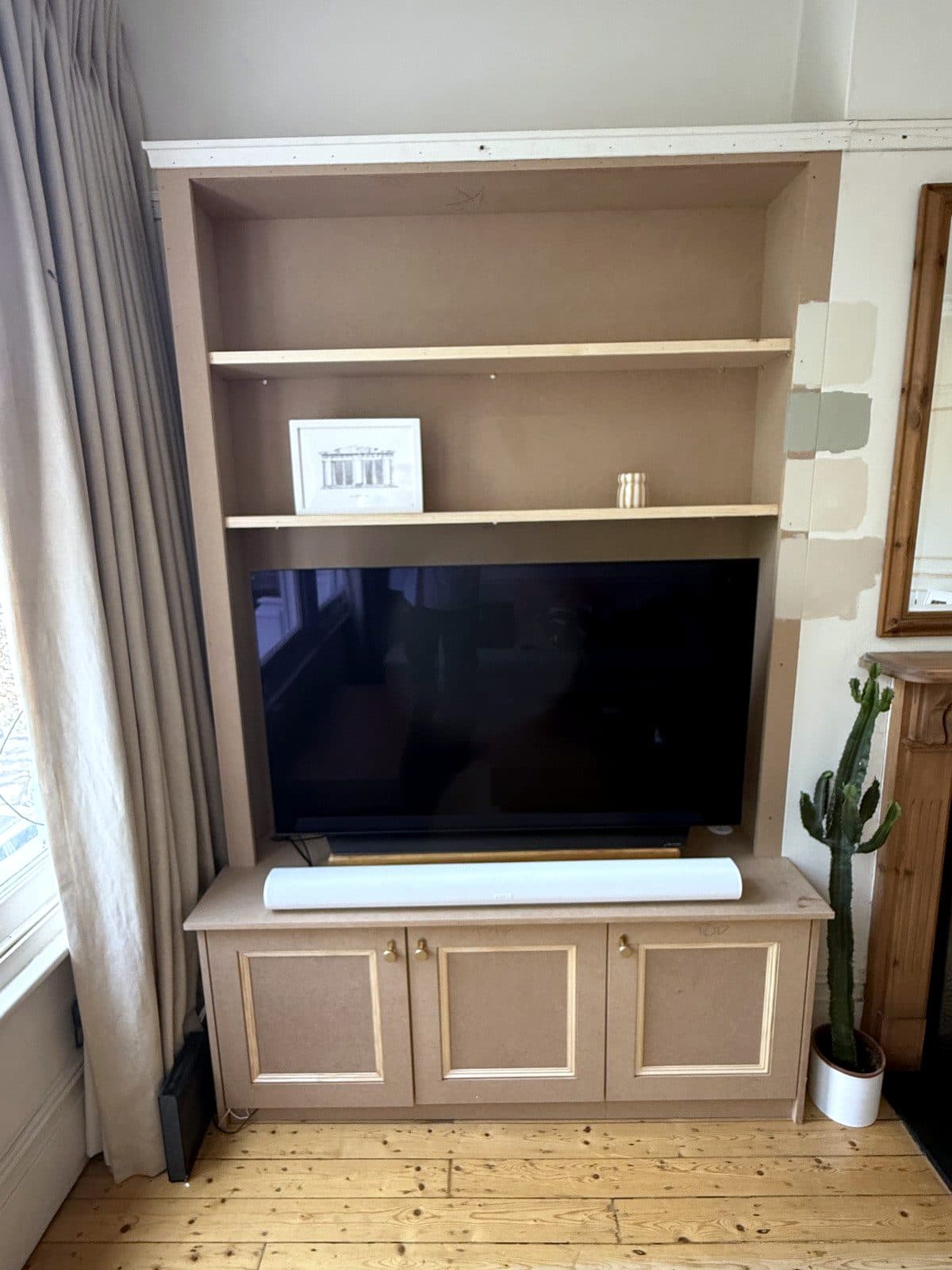 TV unit beside the window, with a soundbar on the cupboard top