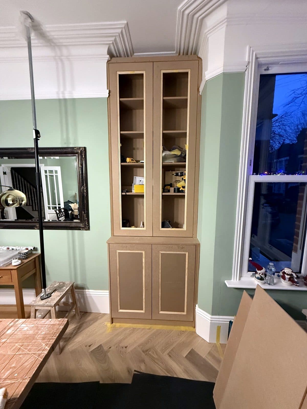 Tall alcove cabinet with framed upper doors and panelled lower doors