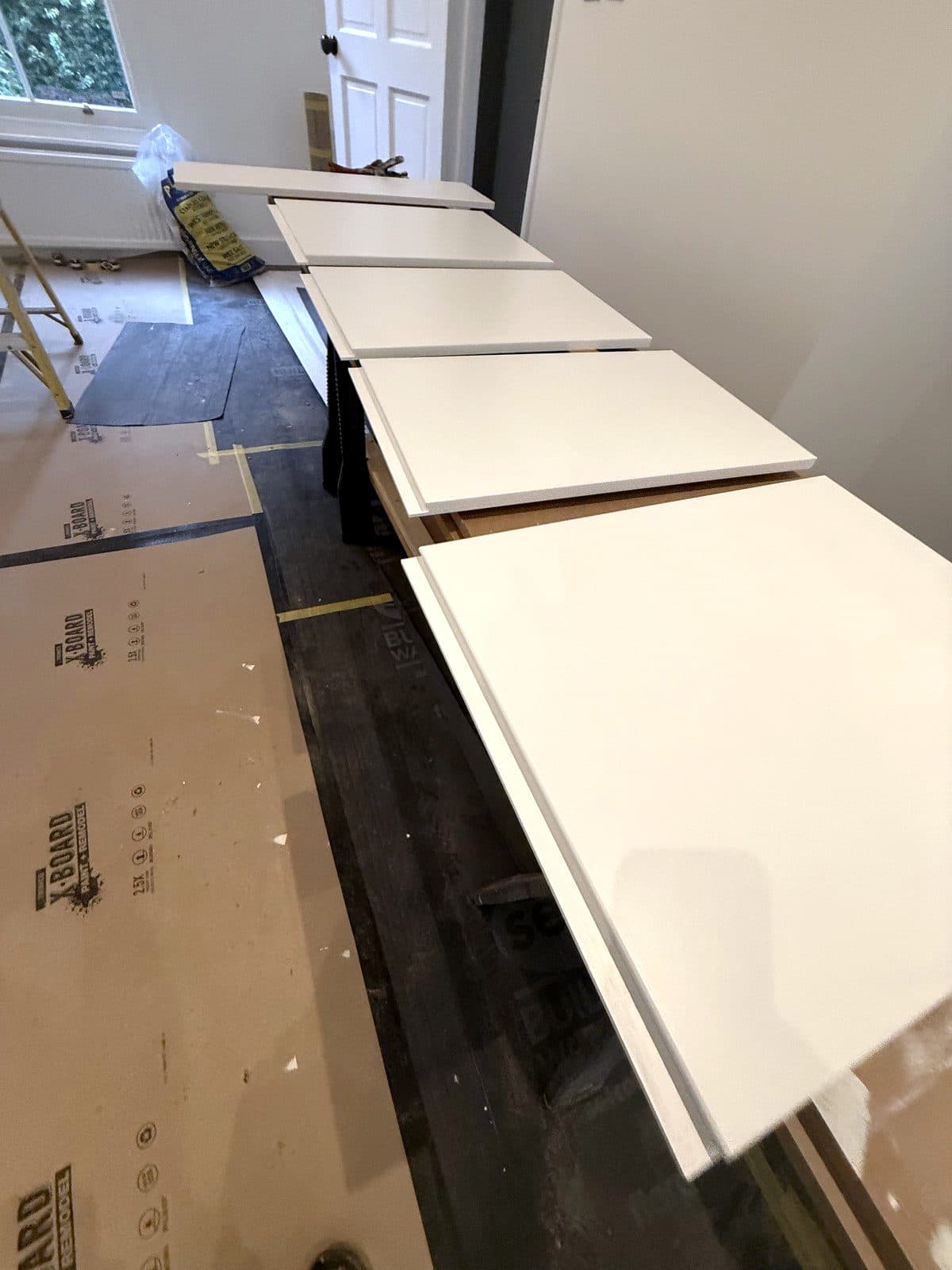 White painted shelves and doors laid out on trestles
