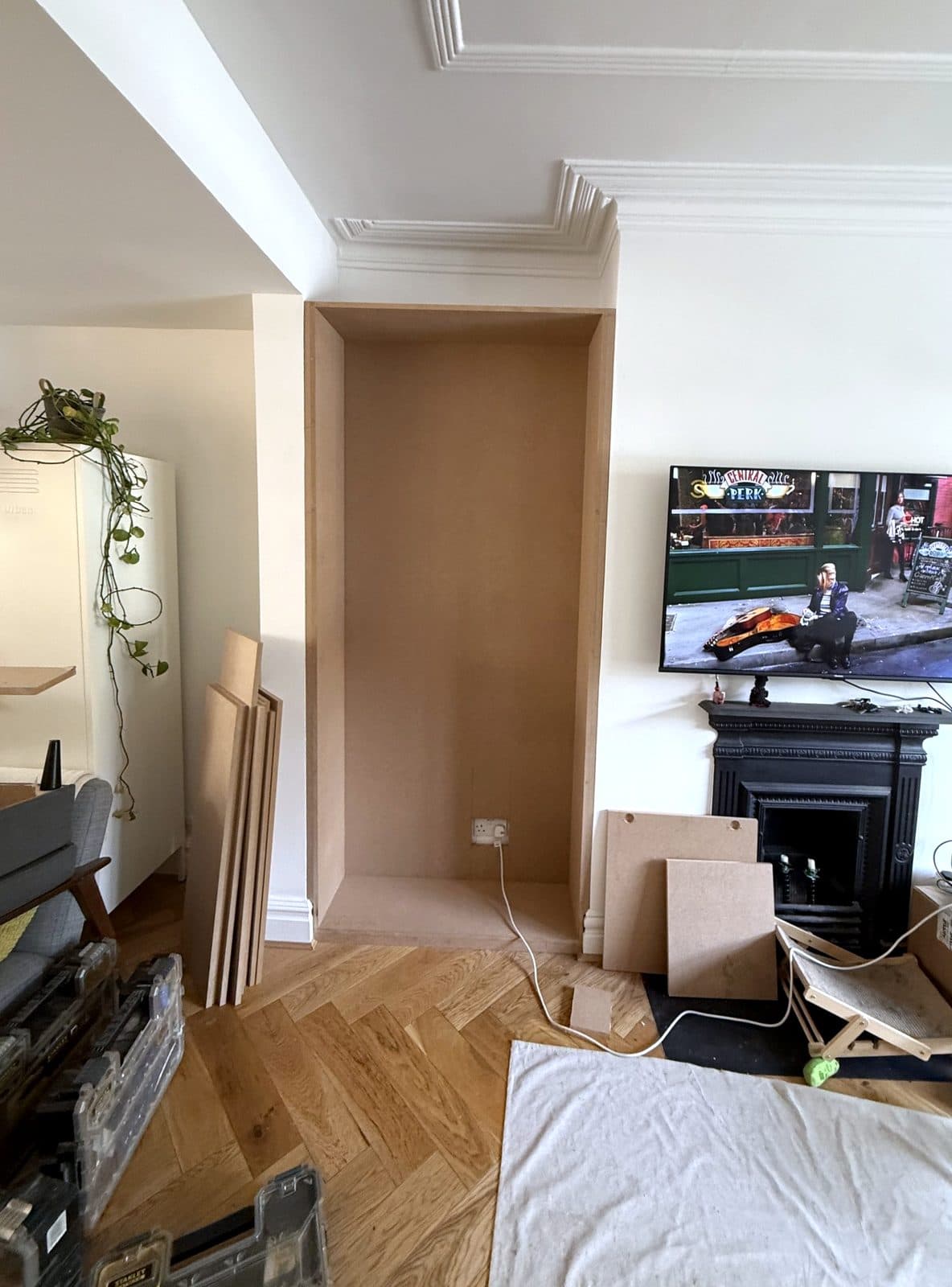 Empty alcove lined with MDF, building materials on the floor