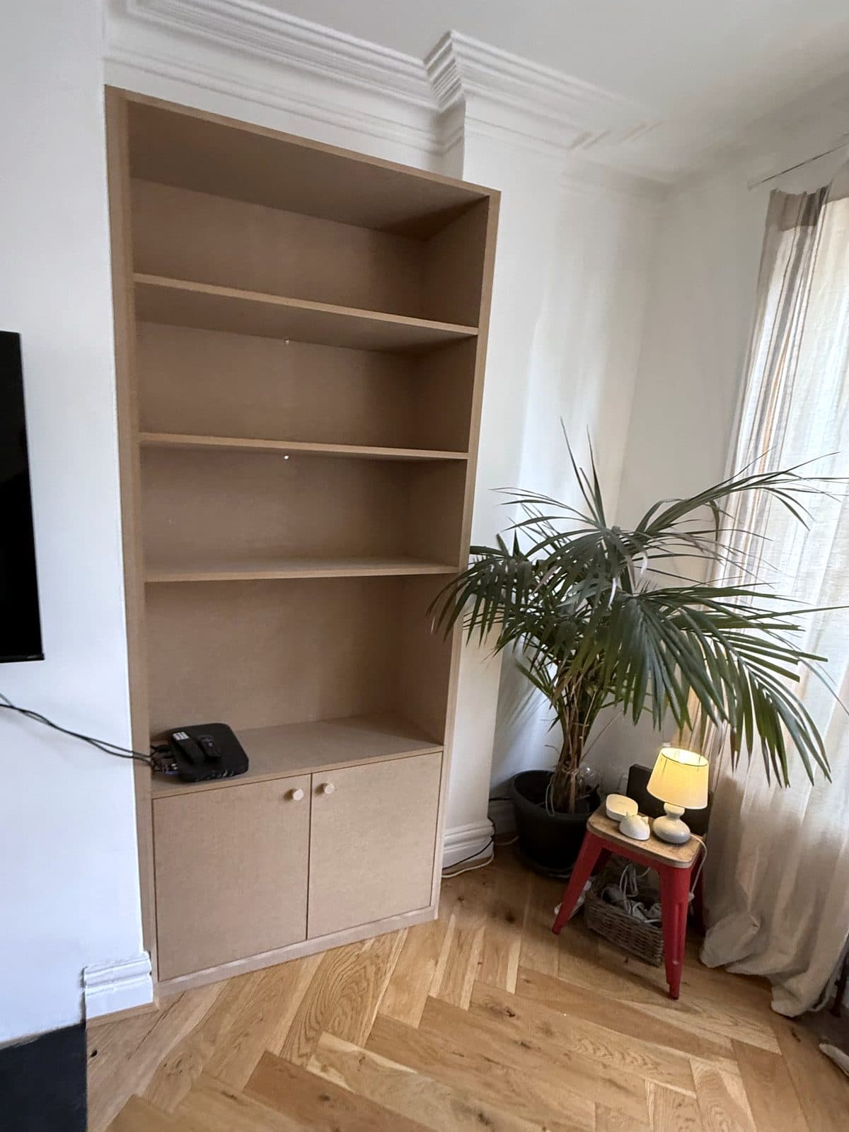 MDF alcove unit with open shelves above a two-door cupboard, beside a fireplace and a palm