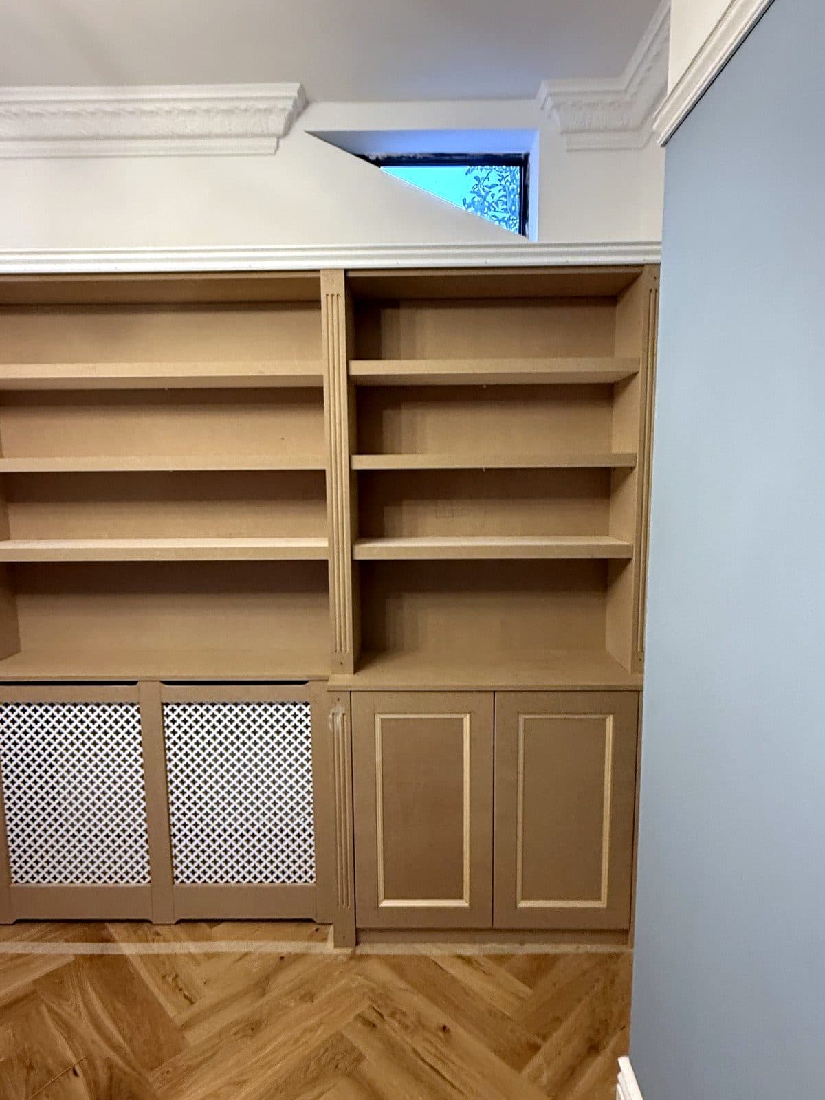 MDF bookcase with shelves above, a grille radiator cover and a panelled cupboard below