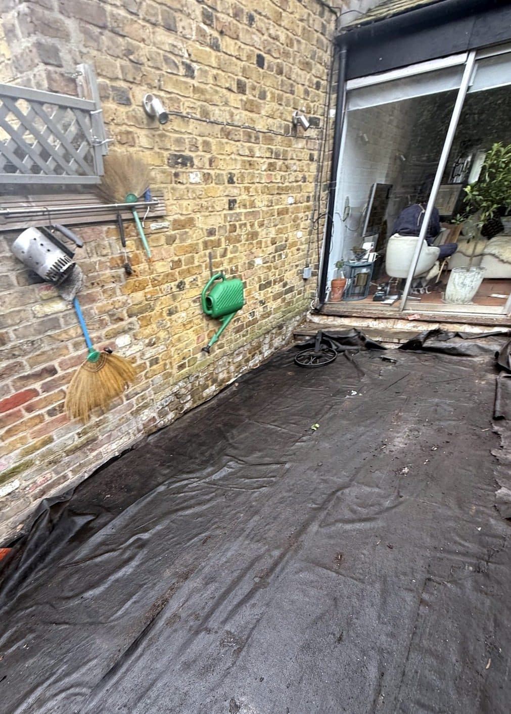 Garden covered in weed membrane before the deck