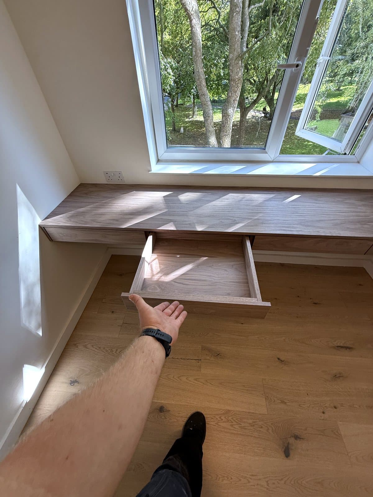 A walnut drawer pulled out from under the desk