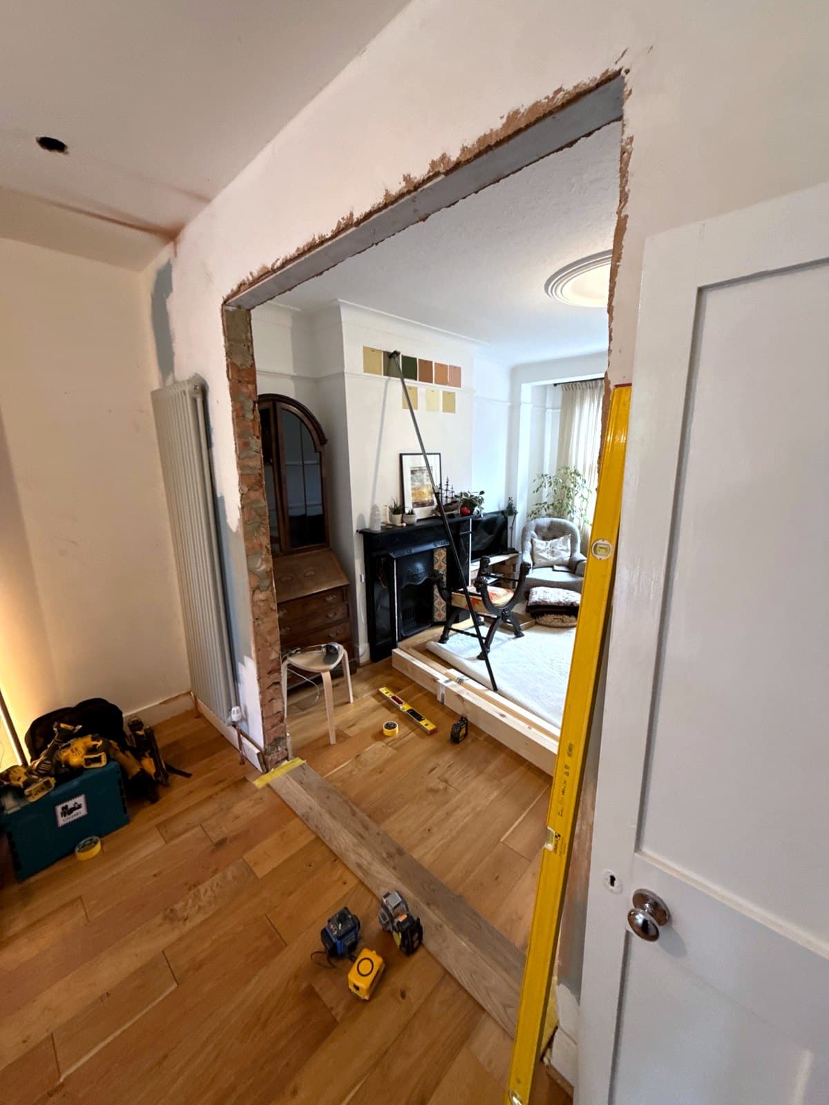 The wide opening between the two rooms, its edges still rough and no frame in it