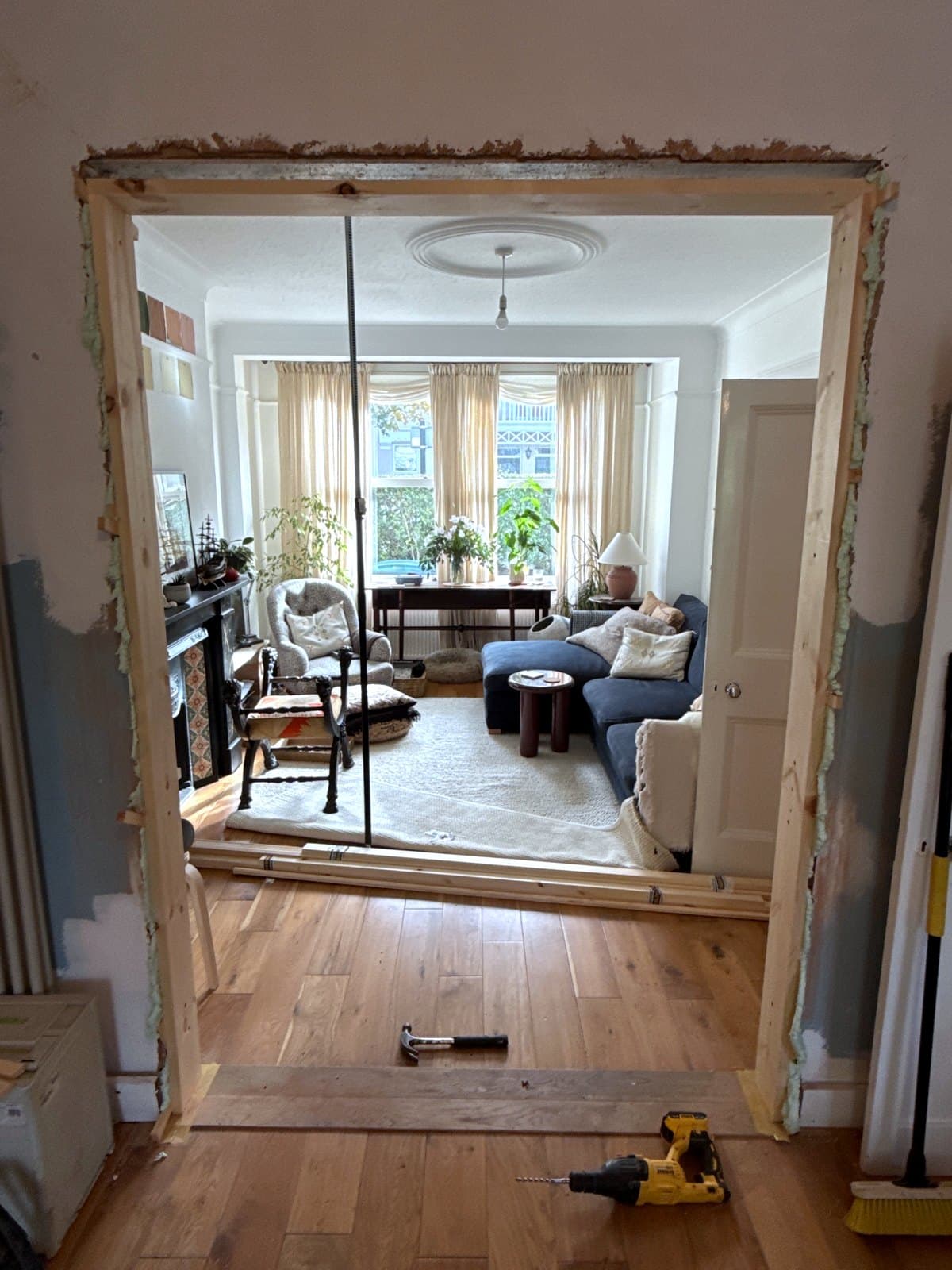 The new frame standing in the opening, propped and checked with a laser level