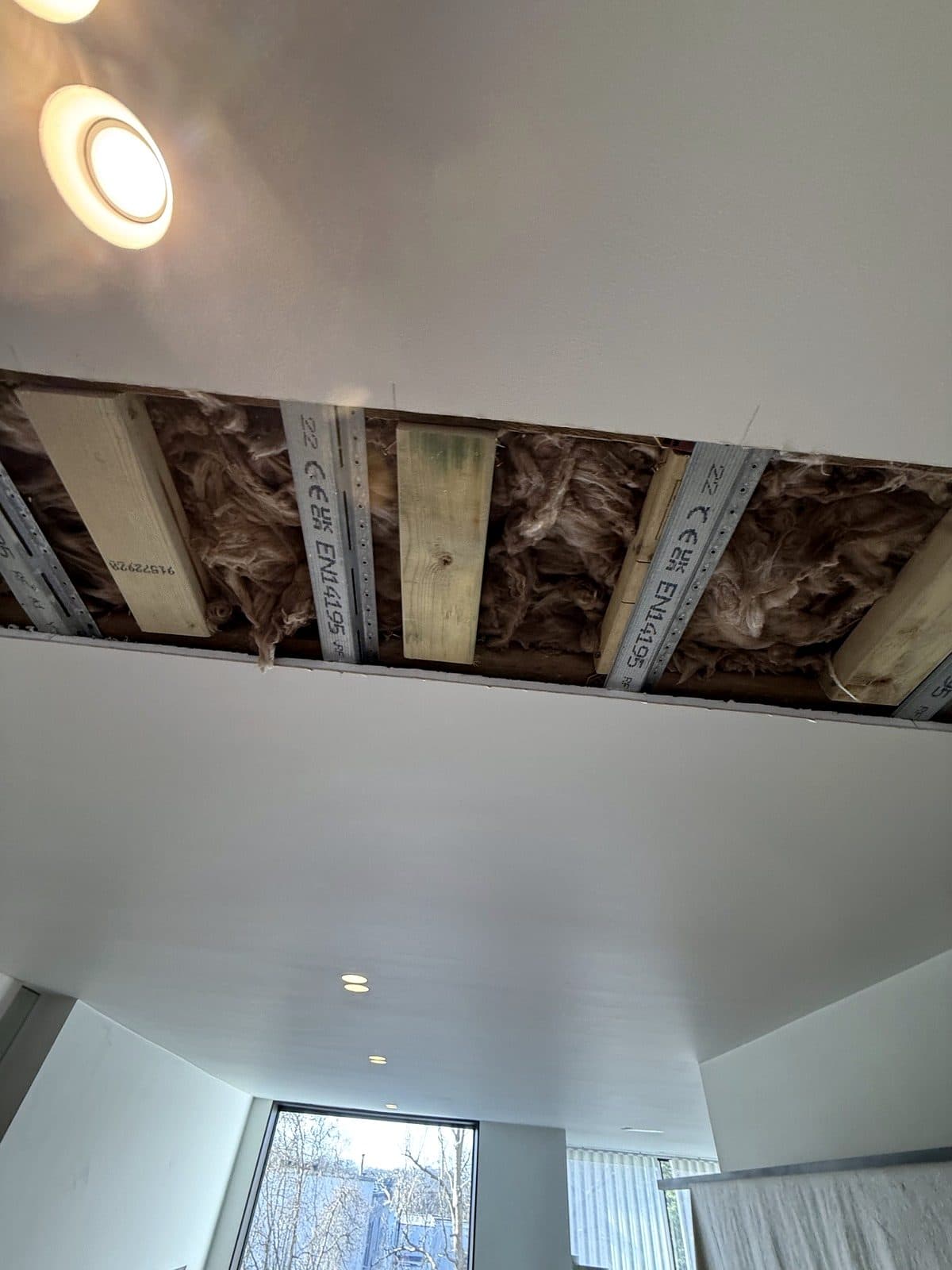 Ceiling opened to show metal joists and insulation