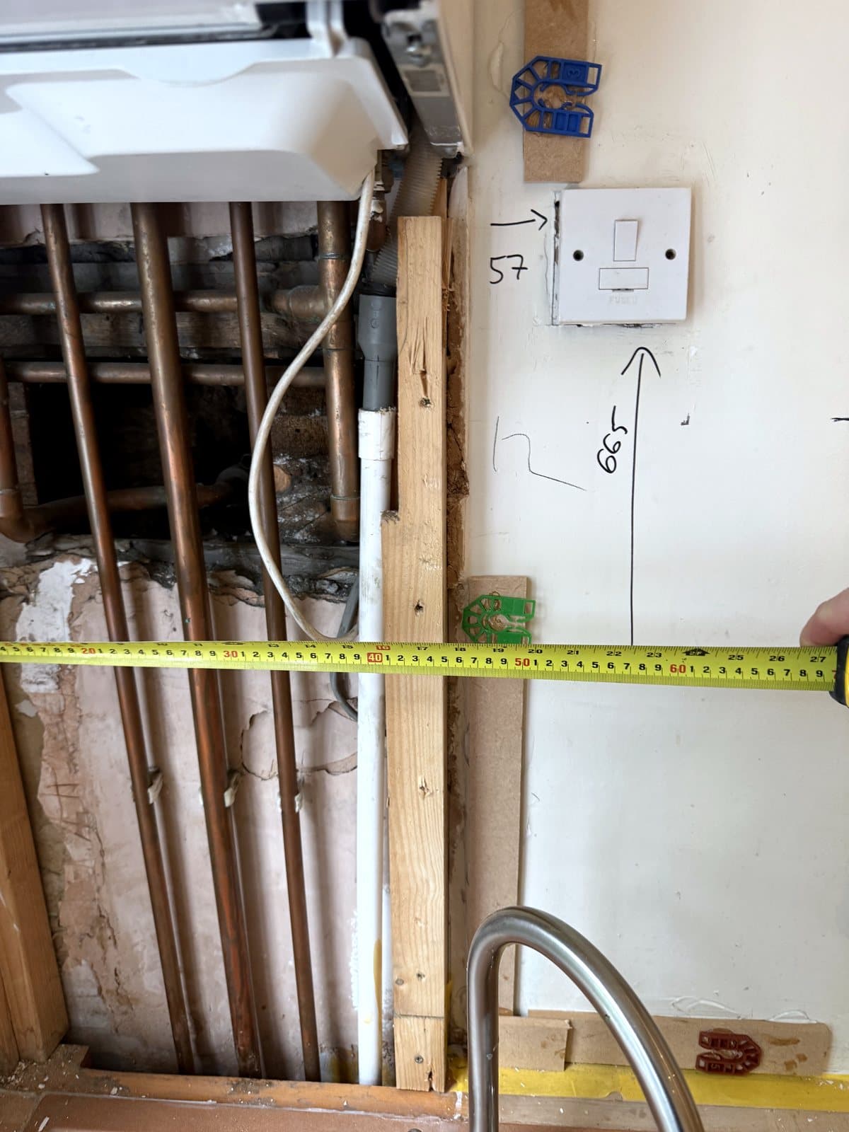 Tape measure across the pipes beside the boiler
