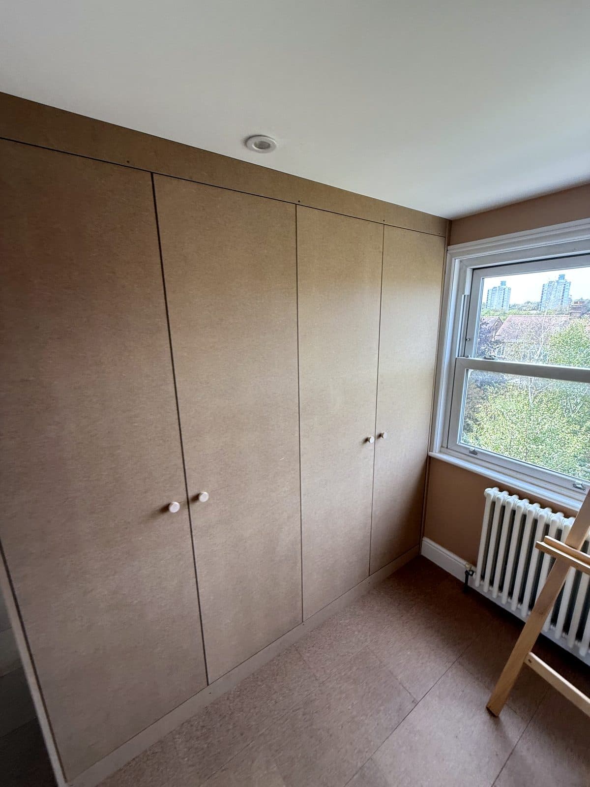 Finished MDF wardrobe with three doors and knobs