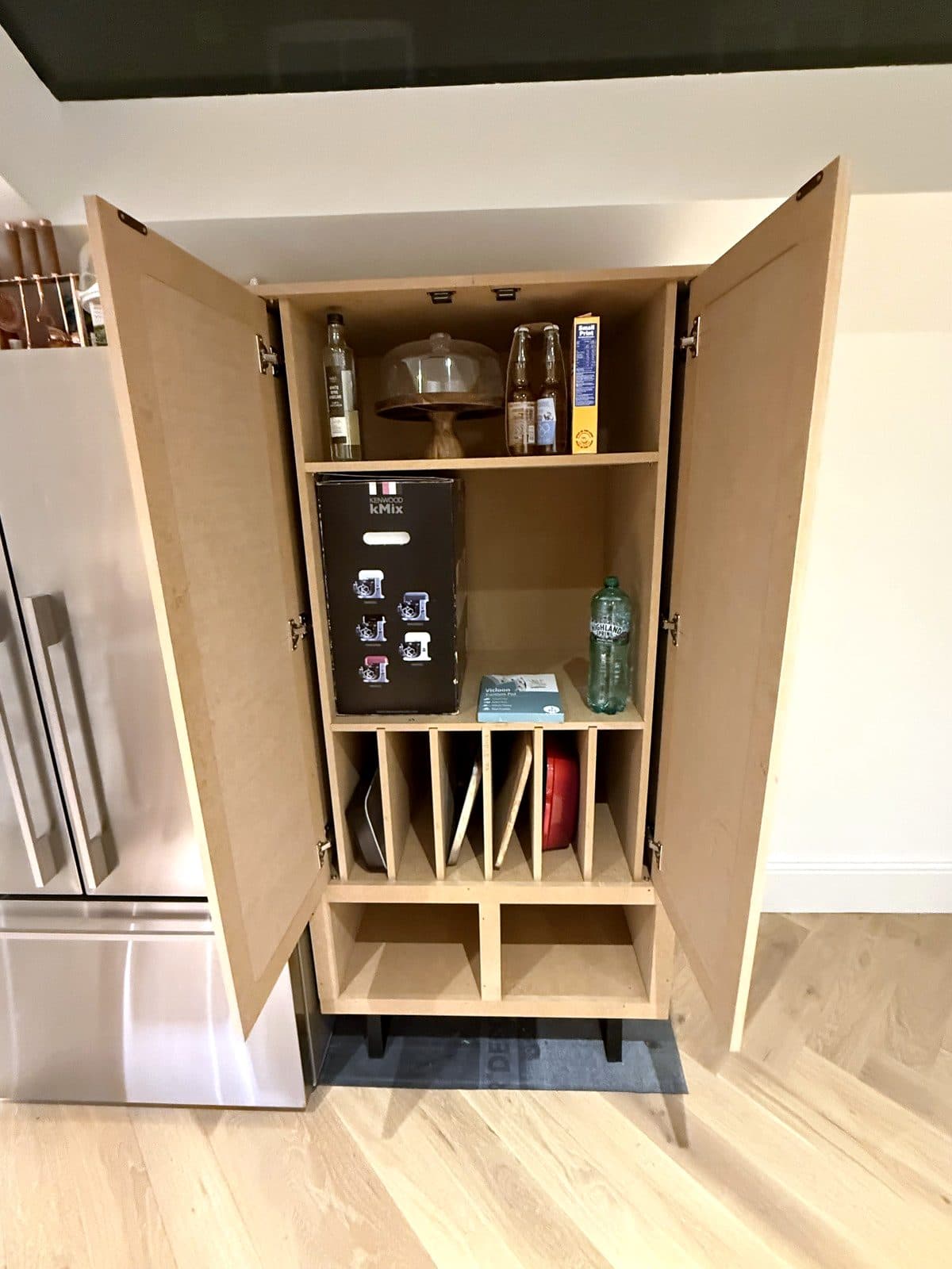 MDF pantry cupboard with both doors open, shelves and tray dividers inside
