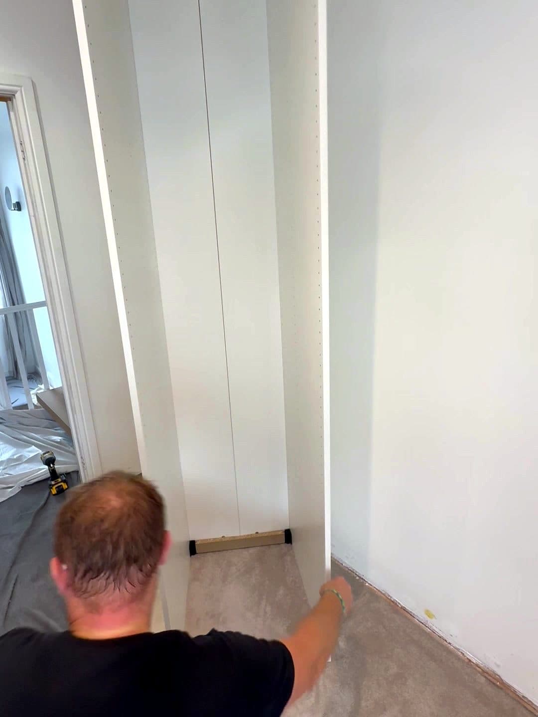 Raf kneeling at the base of a PAX frame by the wall