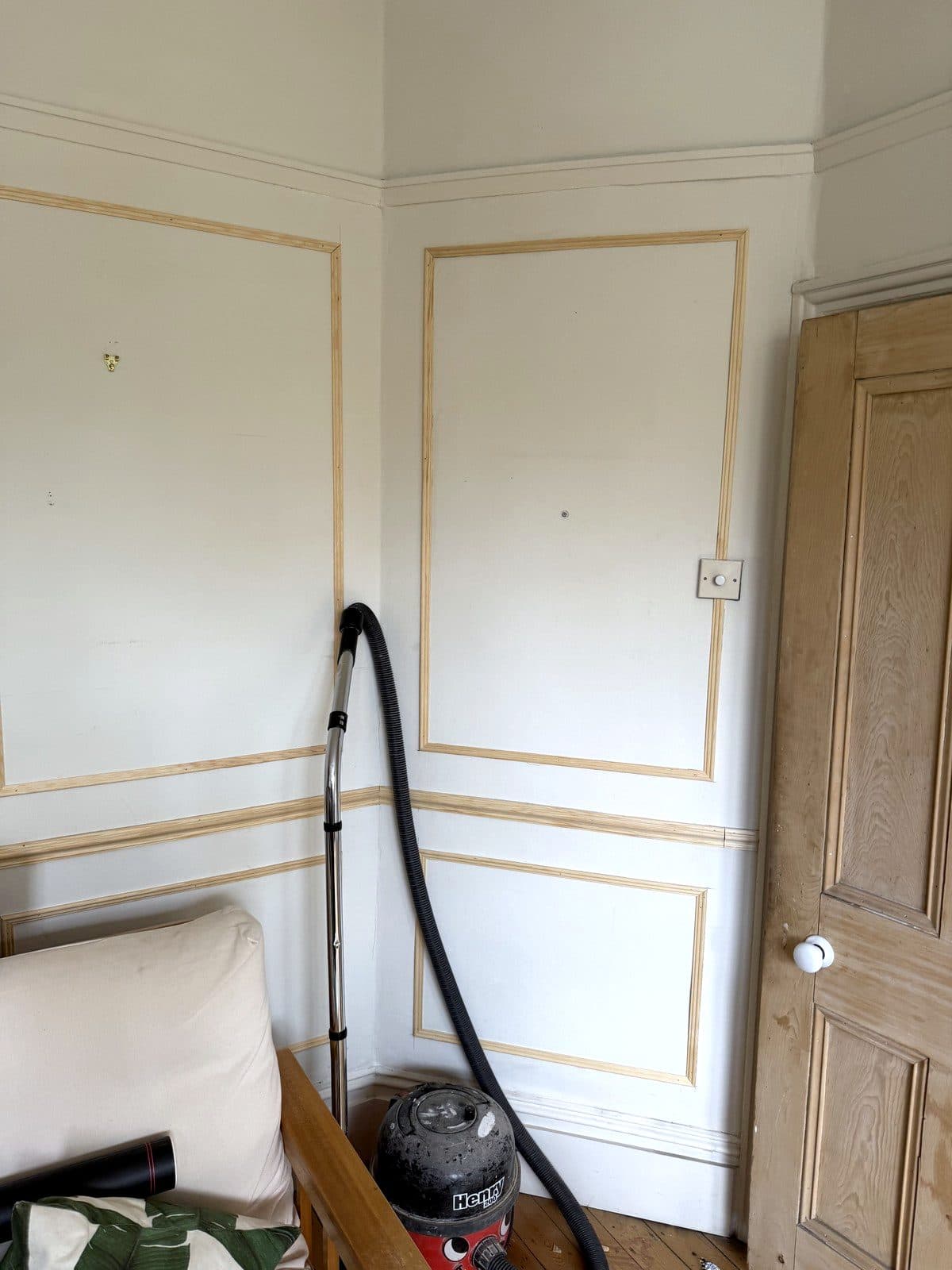Moulding frames fitted on the wall beside a panelled door
