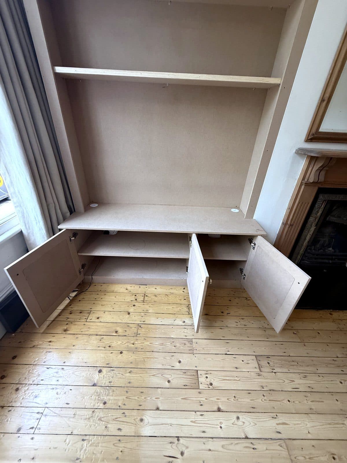 Cupboard doors open, showing a shelf inside the base