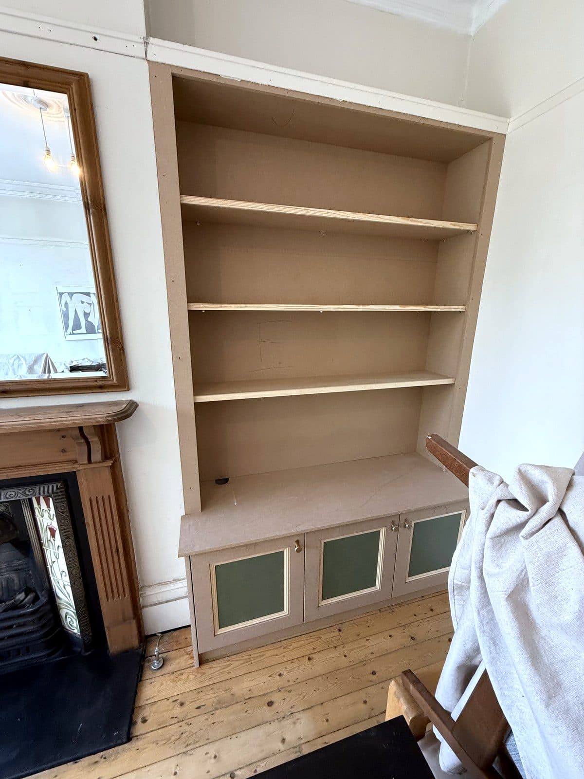 The right alcove bookcase with green panels set into the cupboard doors