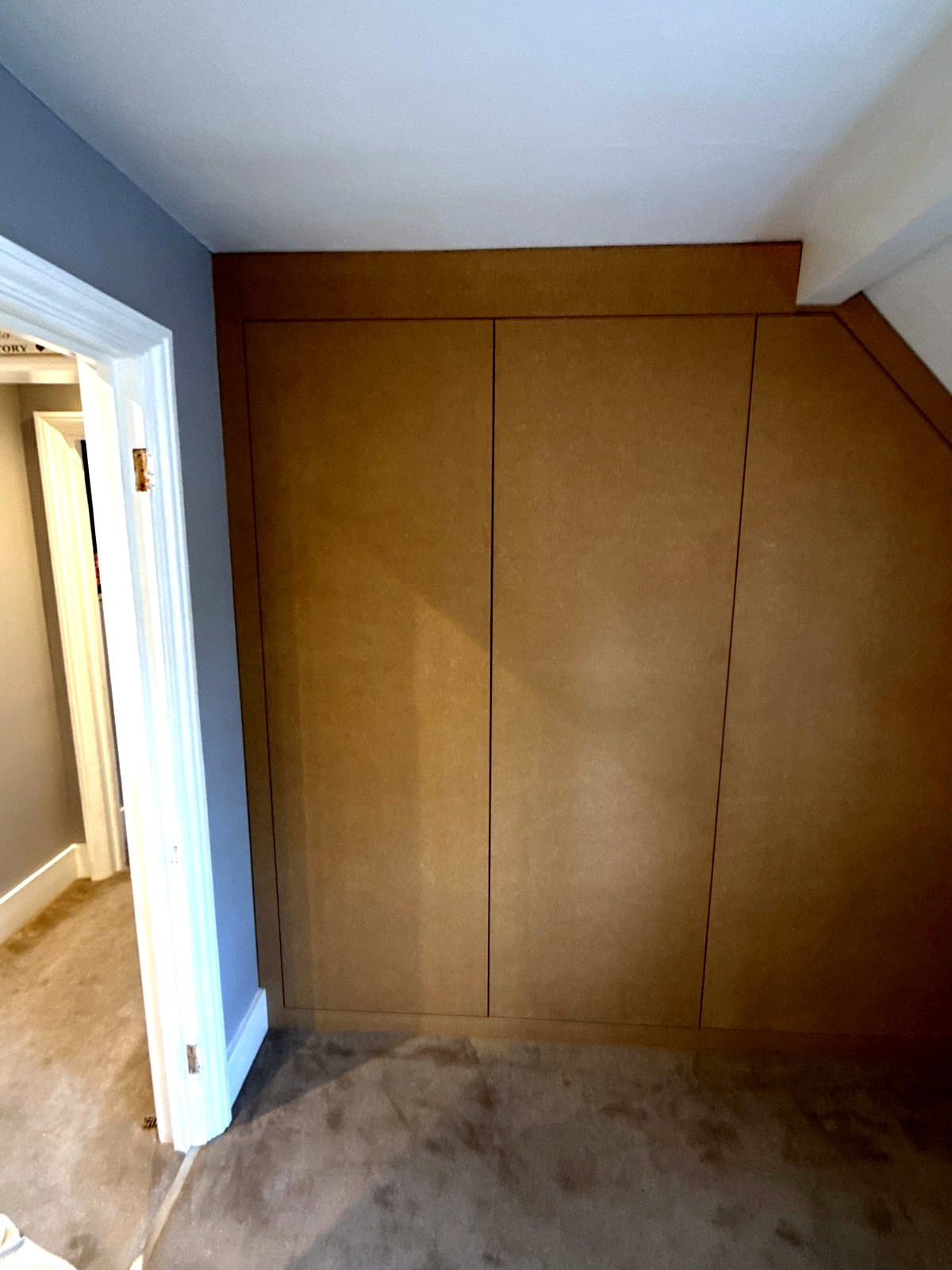 Three flush MDF doors hung across the end of the loft room