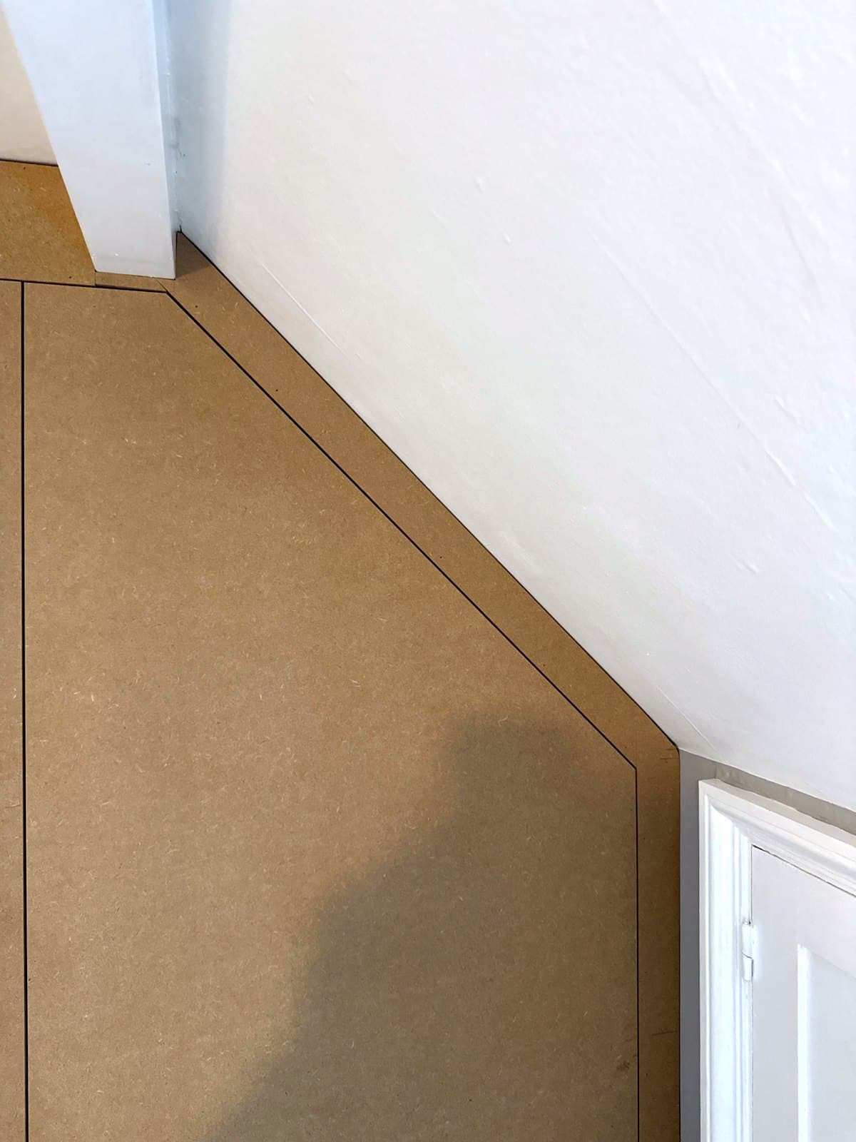 MDF face following the sloped ceiling down to the door frame