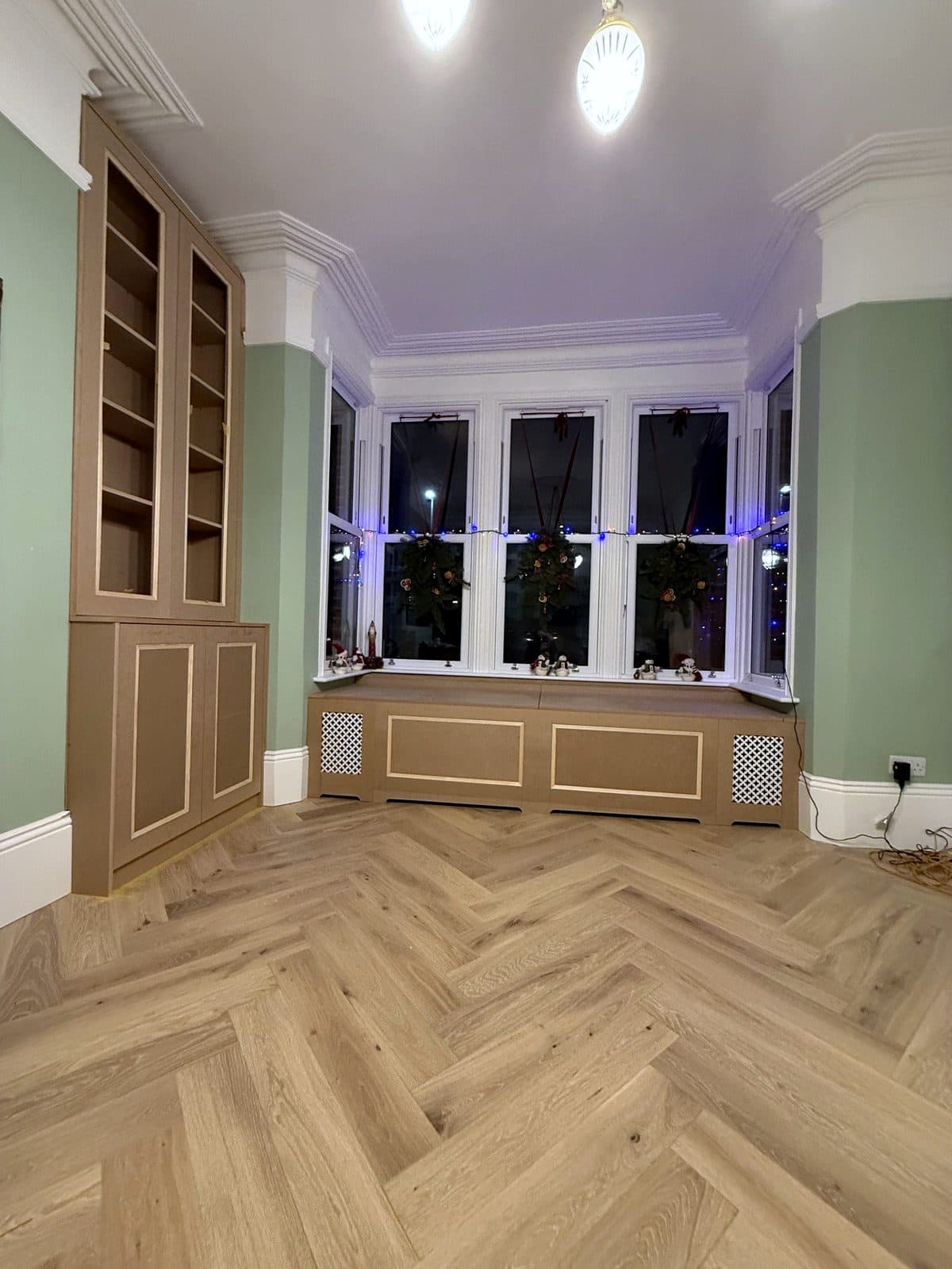 Curved MDF storage bench in a kitchen bay next to a round table