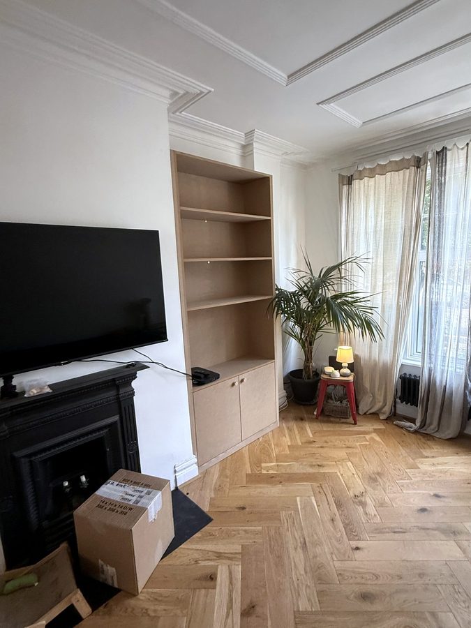 The cupboard alcove seen across the room, next to the bay window