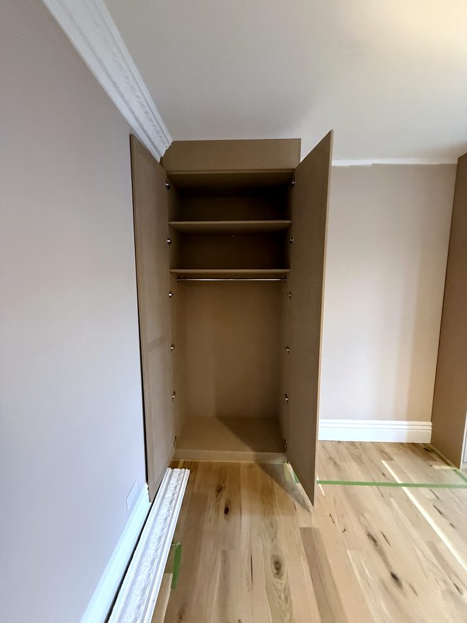 Left wardrobe open, shelves over the hanging space