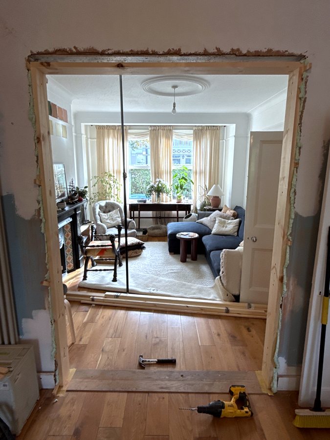 The new frame standing in the opening, propped and checked with the laser