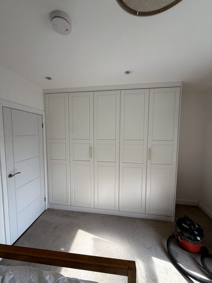 The same wardrobe finished, filled to the ceiling, with gold handles
