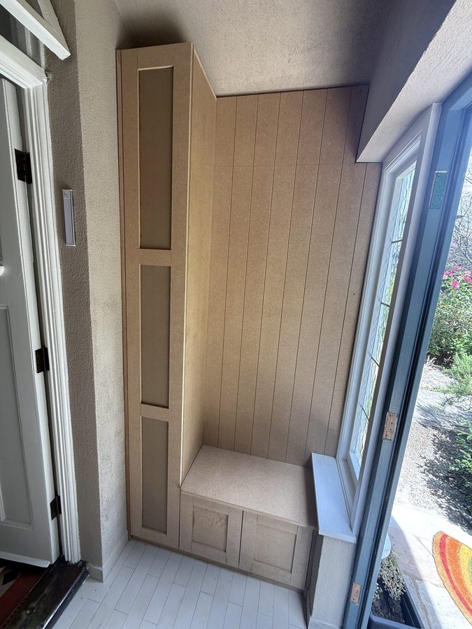 The bench, the boarded wall and the narrow shoe cupboard