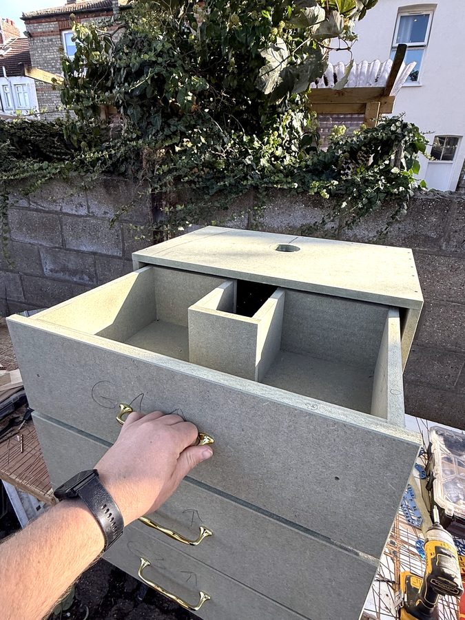 The top drawer in raw board, with the box in the middle