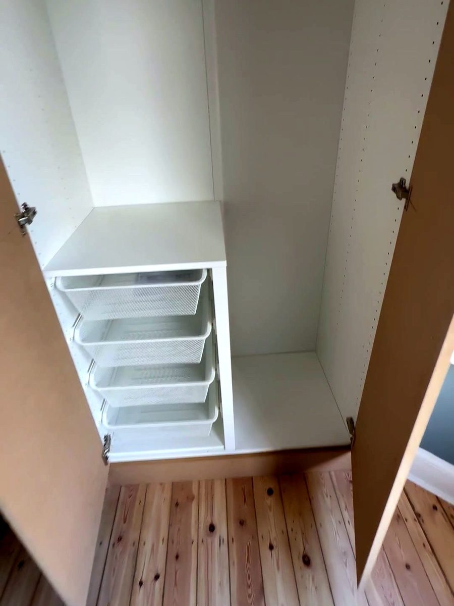 Wire baskets in a wardrobe beside a chimney breast