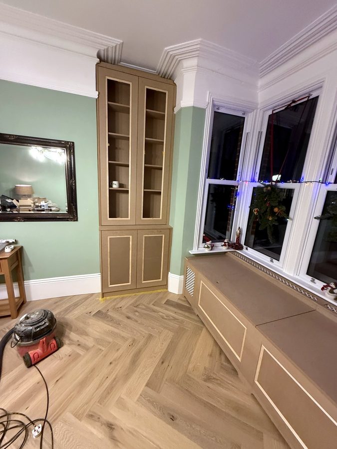 The alcove cabinet beside the chimney breast, with the window seat to the right