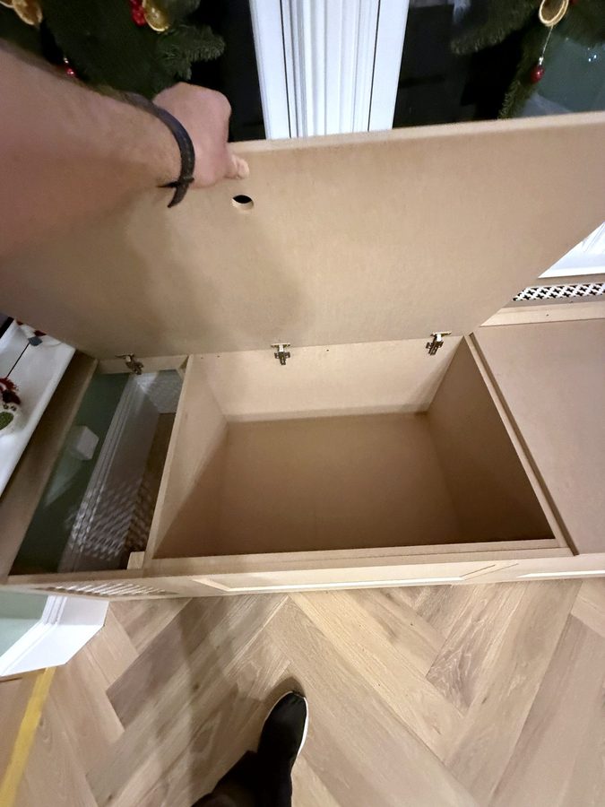 A seat lid lifted, showing the storage box inside