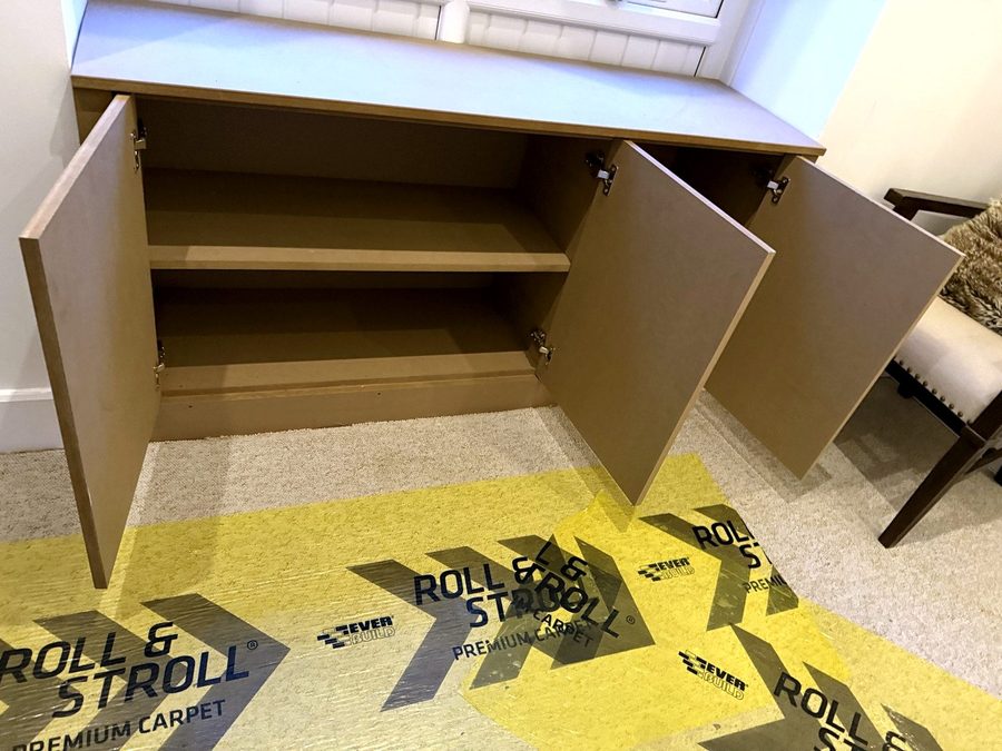 All three doors open, with a shelf across the wide cupboard